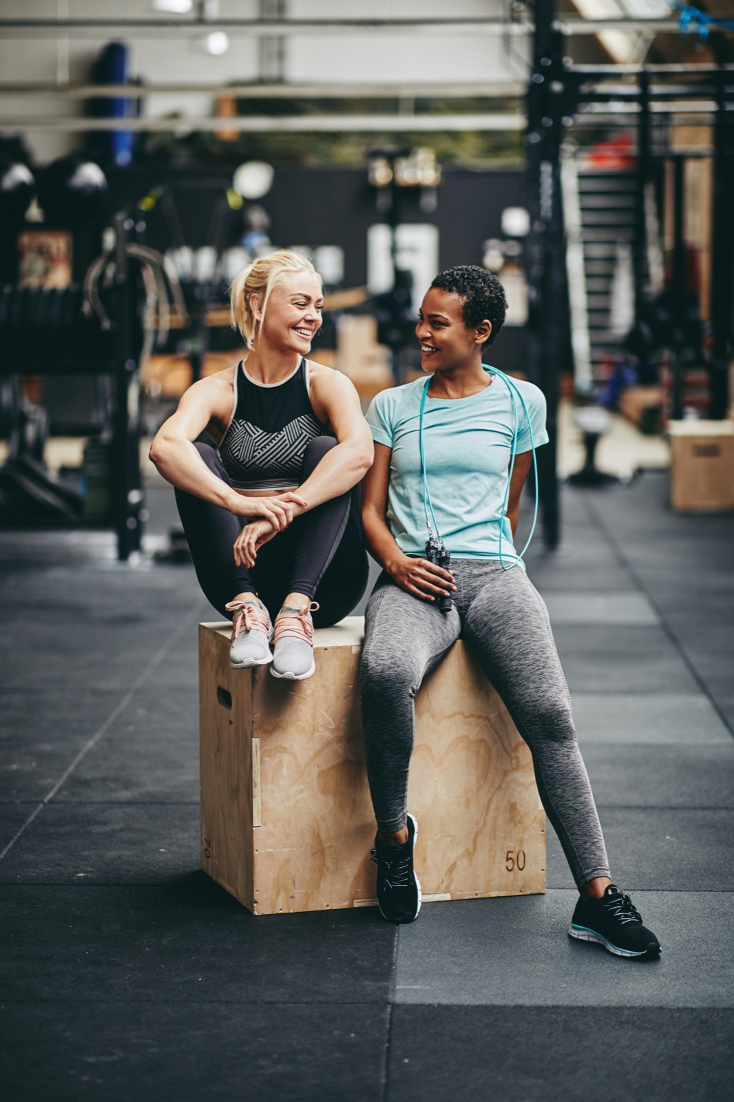 Two friends laughing together after a gym workout — challenge buddies in Velko